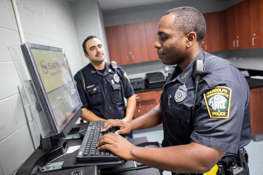 Two male Randolph police offers chat at a computer.