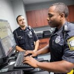 Two male Randolph police offers chat at a computer.