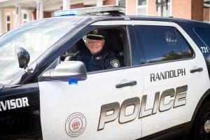 A male cop sit in a Randolph Police patrol car.